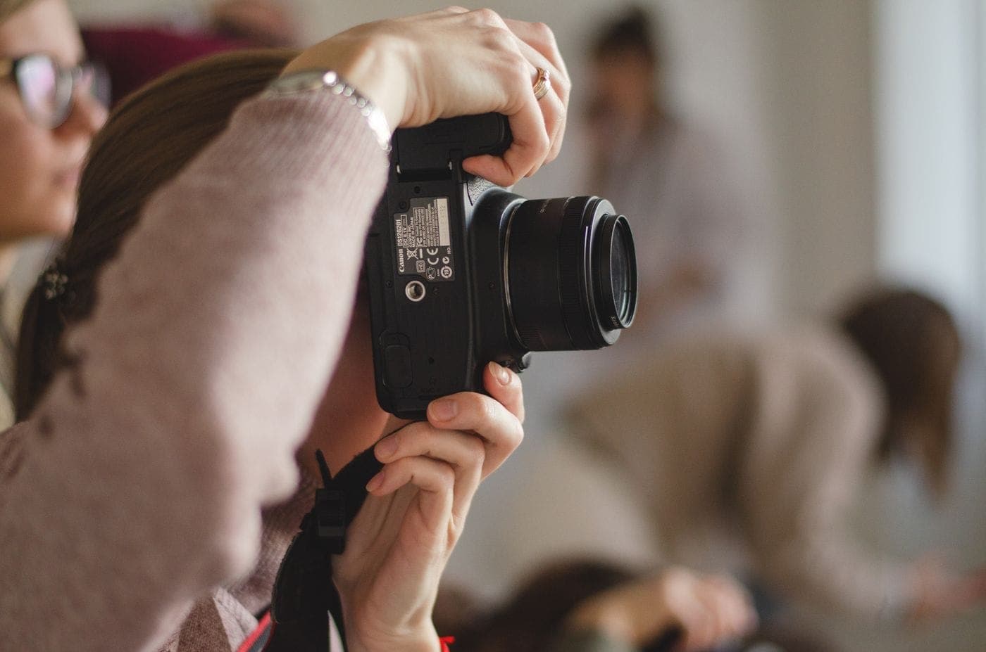 Fotografin hält eine Kamera vor das Gesicht