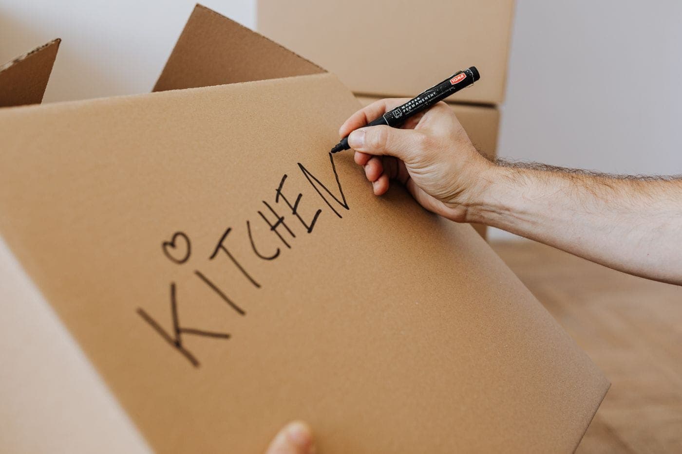 Umzugskarton wird mit einem Stift beschriftet